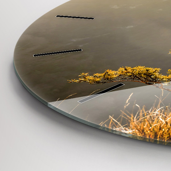 Orologio rotondo Un albero in montagna